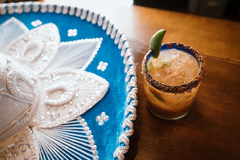 Spicy margarita with a jalapeno and chili-salt rim beside a sombrero at El Mariachi Mexican restaurant in Hampton Bays